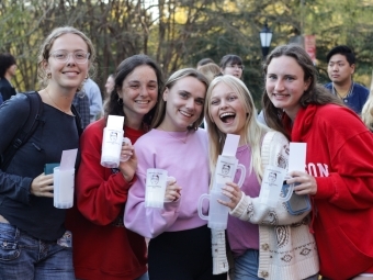 Smiling students with Doug mugs