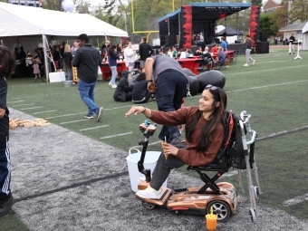 Student in wheelchair throwing a bean bag on football field