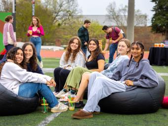 Group of students sitting in bean bag chairs sitting on football field