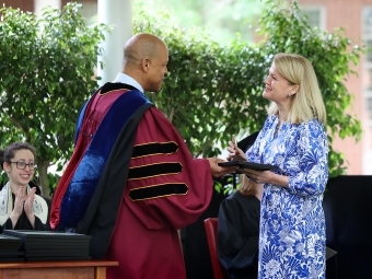 Two people embrace on stage as one accepts an awards