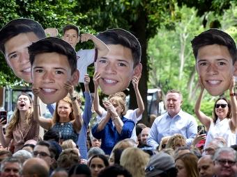 Family holds fat heads of son in graduation crowd