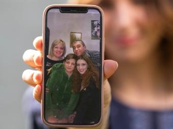 Valeriia Kruzhkova Ukrainian Refugee showing a photo of her family on a cell phone