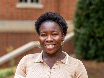 student smiling at camera wearing a beige polo