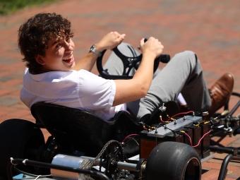 Student smiling and driving gokart