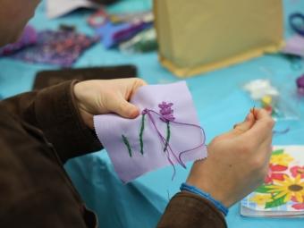 Student working on embroidery project in the DACE Studio