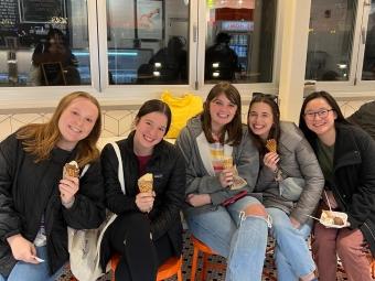 a group of five young women holding ice cream cones in a shop
