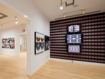 an art exhibit depicting mixed media and a video screen on loop