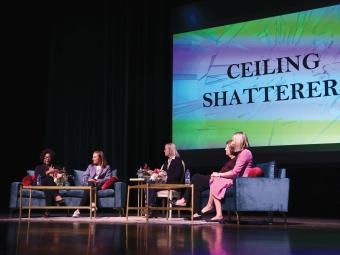 Group of women seated onstage in front of screen that reads "Ceiling Shatterers."