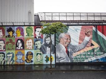 a mural on a street in Ireland depicting many faces