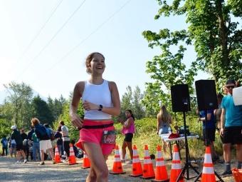 a young woman wears athletics while running a road race