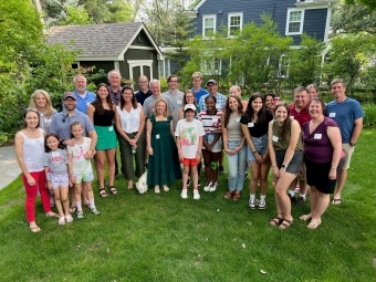a group of students and their families in a green backyard