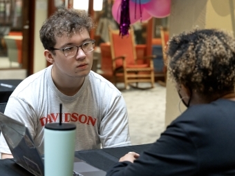 a young man listens to a woman