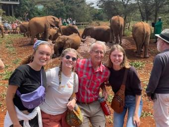 a group of people standing in front of an elephant enclosure