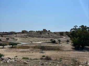 a view of rolling hills with a blue sky in the background