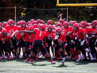 a football team wears red jerseys on a field