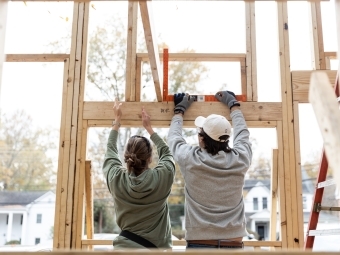 Students constructing walls of tiny house