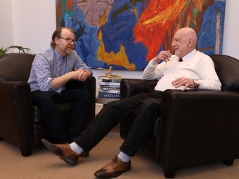 an older white man talking to another man