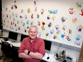 Professor Malcolm Campbell with handprint wall