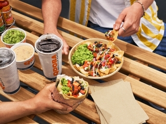 People enjoying a Qdoba Cholula Chicken bowl and drinks