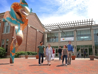 a group of students walk together outside of an academic building