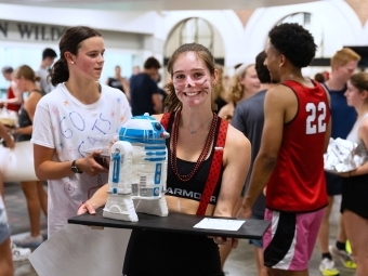 a young woman holds a cake shaped like R2D2