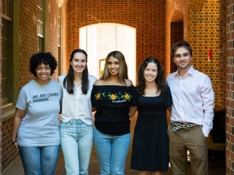 a group of young people standing together in a brick hallway