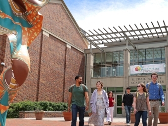 a group of students walk in front of an academic building