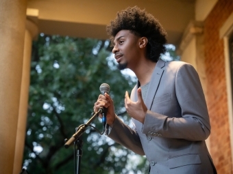 Student speaking at a microphone at the Phi Eu Debate