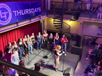 a group of students sing on stage