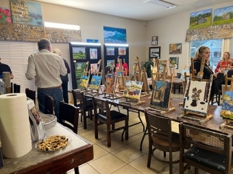 a studio set up with paintings, brushes and more