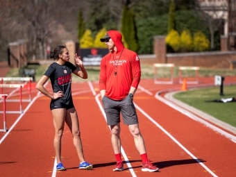 Lisa and Jeff Case Track & Field Complex runner and coach speaking on track