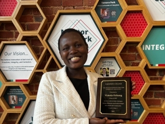 a young Black woman holds an award