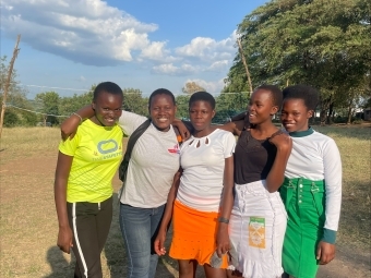 a group of young people smiling on a sunny day