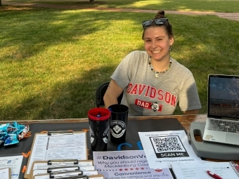 a young woman smiling sitting at a table