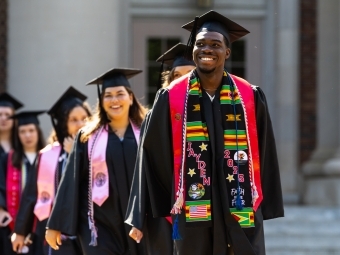 Commencement 2025 students smiling in procession 