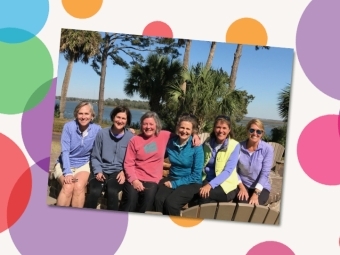 a group of women sitting together in a sunny coastal location