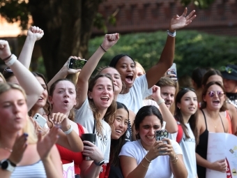a group of students cheer as runners go by