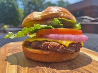 a burger sitting on a wooden cutting board