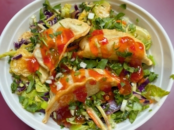 a bowl of greens topped with dumplings