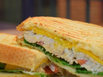 a panini stuffed with chicken, lettuce and cheese