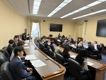 a group of young people sit around in a room working together