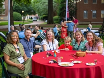 Family and friends smiling at the table at Reunion 2025