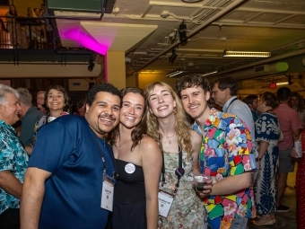 Young alums embrace in the student union at Reunion 2025