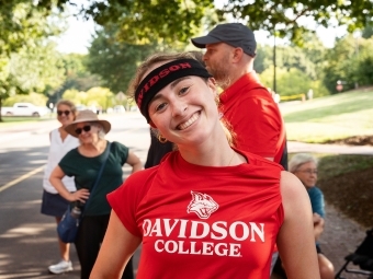 Student smiling with sweatband and Davidson College t-shirt