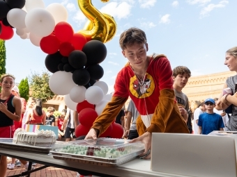 Student in Buc-ees pajama onesie picks a cake after finishing the race