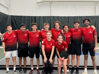 a group of pickleball players on an indoor court wearing red uniforms