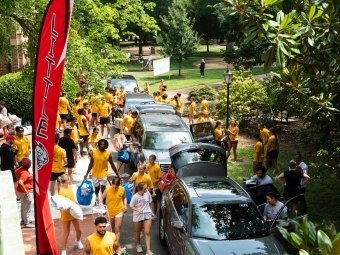 a group of students moving in in a line of cars
