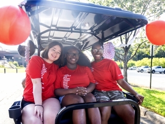 Orientation leaders in red arrive in golf cart