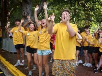 Students in yellow shirts greet class of 2029 students arriving on campus