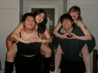 four college students smile together 